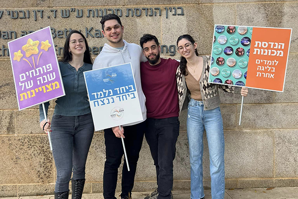 סטודנטים בפקולטה להנדסת מכונות עם שלטי קבלת פנים לפתיחת השנה